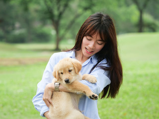 Asian woman playing puppy dog in park