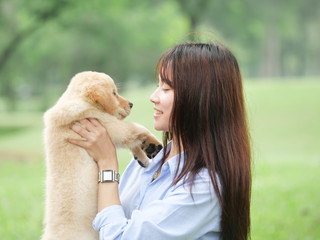 Asian woman playing puppy dog in park