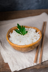 Bowl with white rice on the wooden background, wabi sabi style