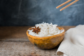 Bowl with white rice on the wooden background, wabi sabi style
