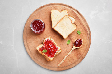 Toasts with jam on wooden board, top view
