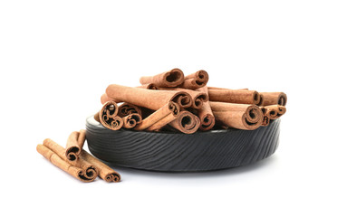 Bowl with aromatic cinnamon sticks on white background