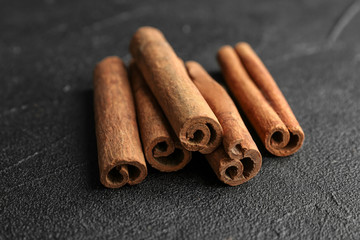 Aromatic cinnamon sticks on dark grey background