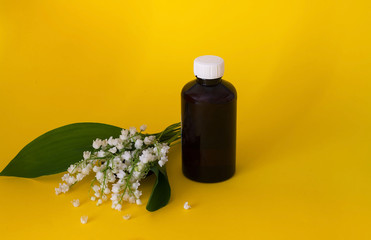 Lily of the valley, essential oil Convallaria majalis (extract, tincture,  remedy) with fresh flowers Convallaria on a yellow background, concept of ecological ingredients, copy space, close-up