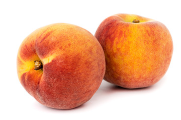 Two ripe peaches on a white background, close up.