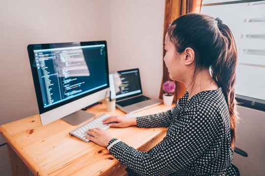 Beautyful programmer women working at home with laptop and computer pc. Woman writing, coding for create program. Bolt hand typing on keyboard.