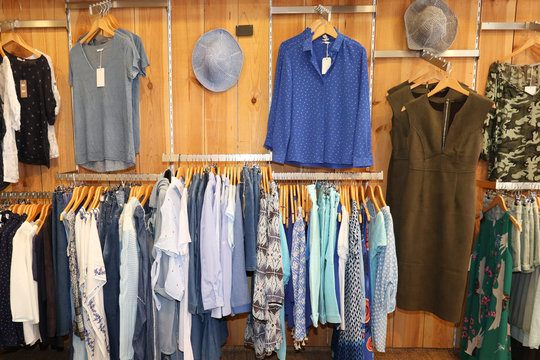 Variety of clothes hanging on rack in boutique interior view of women clothing store