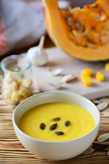 pumpkin cream soup with seeds on a wooden table