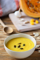 pumpkin cream soup with seeds on a wooden table