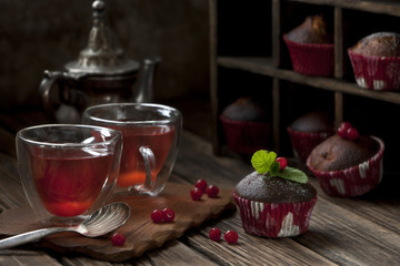 Homemade muffins with blueberries and cup of tea on a vintage wooden background.  Selective focus, shallow depth of field.