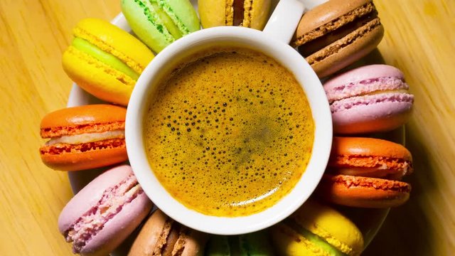 Macaroon cookies and coffee cup rotates