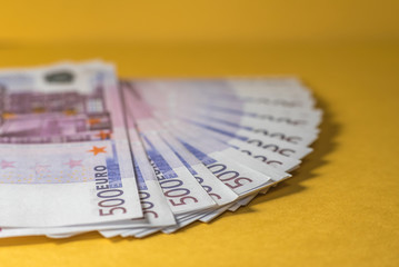 Many euro bills closeup on yellow background