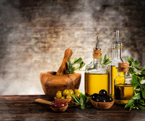 Fresh harvested olives with oil, placed on wooden table