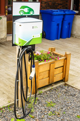 Charging Point for Electric Vehicles in Fornt of an Old Brick Building © alpegor