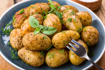 baked potatoes, blue plate, close-up, home kitchen, potatoes in the peel
