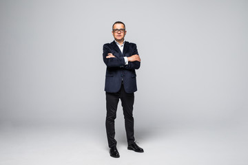 full length picture of a mid aged business man smiling with his arms crossed. isolated on white background