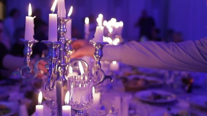 Hands of people with glasses of champagne or wine or whiskey, celebrating and toasting in honor of the wedding or other celebration, candlelight dinner
