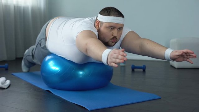 Obese hardworking man practicing static exercise, strength training program