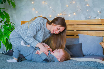 Happy young mother and her baby son playing togerher