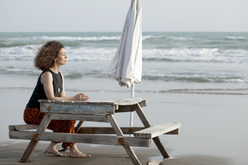 woman making yoga meditation at the beach