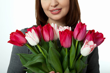 Mothers Day Beautiful woman with flowers tulips in hands on white background. Mother's Day concept.