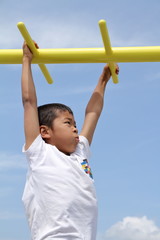 Fototapeta premium 雲梯で遊ぶ小学生(3年生)