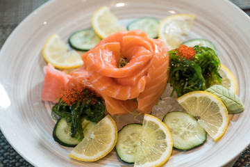 japanese food, salmon flower  with cucumber and lemon slices on ice dish. sushi concept