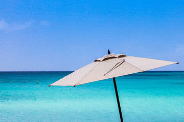 Obraz na płótnie Canvas Umbrella with blue sky and ocean
