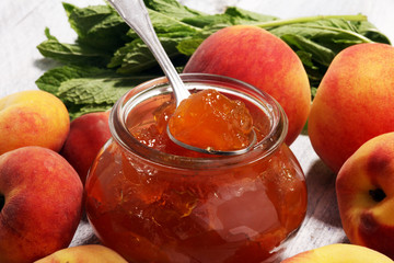 Peach vanilla jam with fresh peaches on table.
