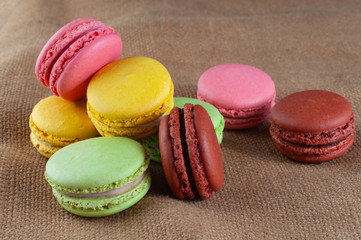 Macarons cakes of different colors on a burlap