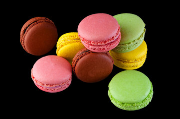 Macaron cakes of different colors on a black background