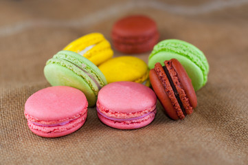 Fototapeta na wymiar Macarons cakes of different colors on a burlap