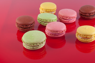 Macaron cakes of different colors on a red background