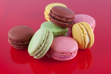 Macaron cakes of different colors on a red background