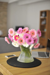 A bouquet of fresh flowers in a vase on the table. Home interior. Comfort