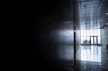 The room is after repair with a covering of walls and floor with ceramic tiles with reflection.