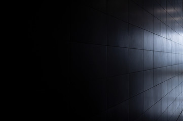 Ceramic tiles on the wall, surface lighting with a gradient from dark to light.