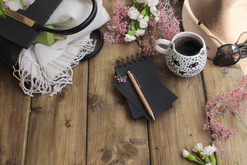 Obraz na płótnie Canvas Black fragrant coffee, flowers, hat, bag and glasses. Good morning, bright sunny colors. Women's accessories and notepad with a pen. Planning the day