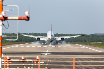airplane landing with airport beacons in daylight
