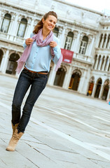 Happy young woman walking on piazza san marco in venice, italy