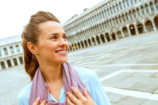 happy young woman on piazza san marco in venice, italy