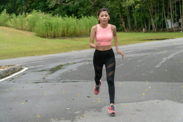 Beautiful young woman sportswear jogging in the Park. Female athletes is exercising to take good care of her health.