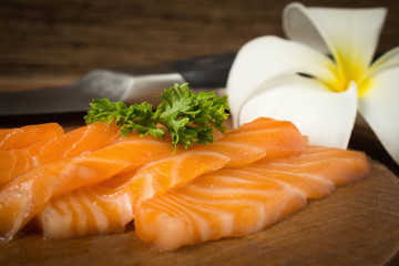 salmon sushi on cutting board with flower closeup