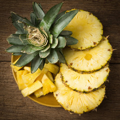 pineapple on dish slice on old wood