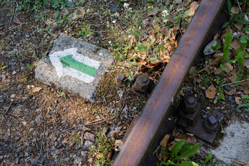 Markings of the tourist route on railway sleepers. Old railway line in a forest area.
