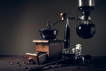 Obraz na płótnie Canvas Japanese siphon coffee maker and coffee grinder on old kitchen table background, It is very fragrant and aroma because filled with fresh coffee beans.