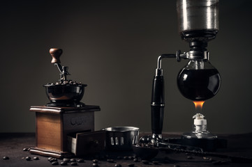 Japanese siphon coffee maker and coffee grinder on old kitchen table