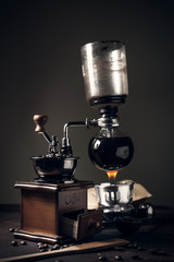 Japanese siphon coffee maker and coffee grinder on old kitchen table
