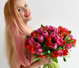 Beautiful woman hold bouquet of red and pink tulip flowers happy smiling on grey 