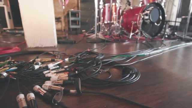 Drums in Recording Studio Tilt Down to Mic Cables. a wide low angle view of a drum set in a recording studio and tilts down to drum mic cables